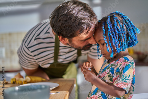 Affectionate father and cute toddler daughter in kitchen photo