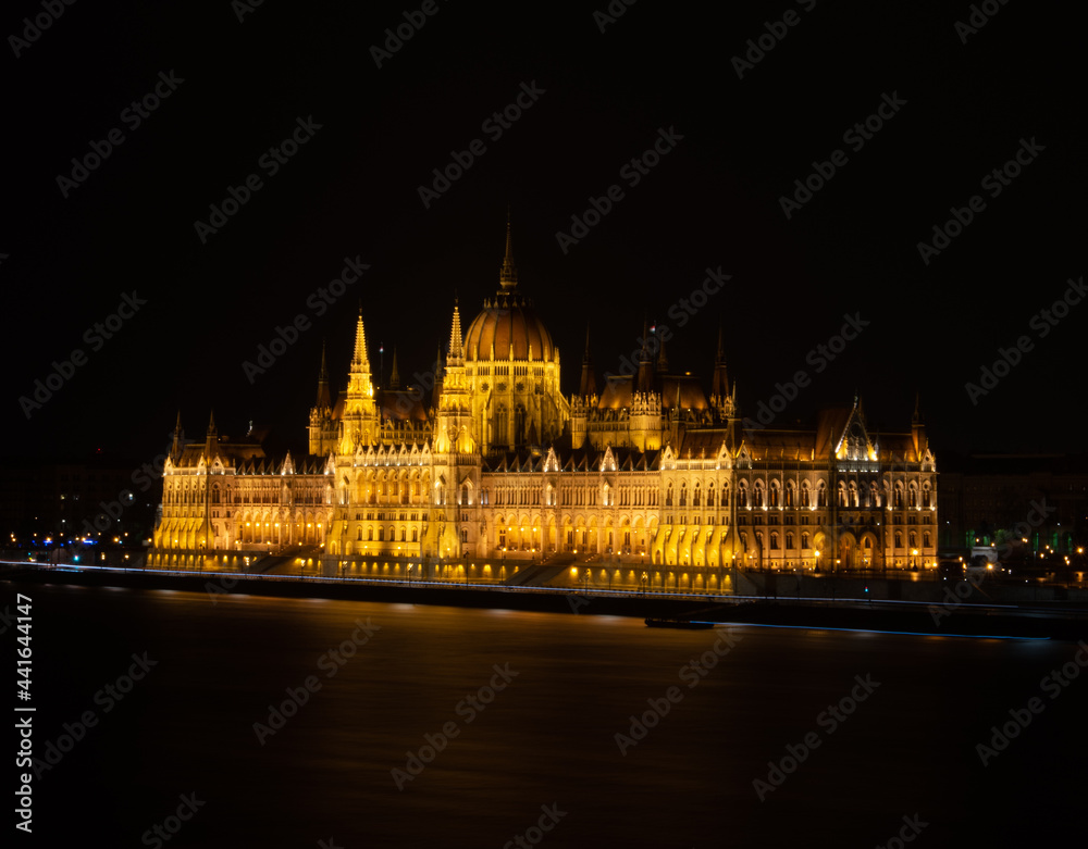 Obraz premium Budapest's majestic parliament lighting up the night.