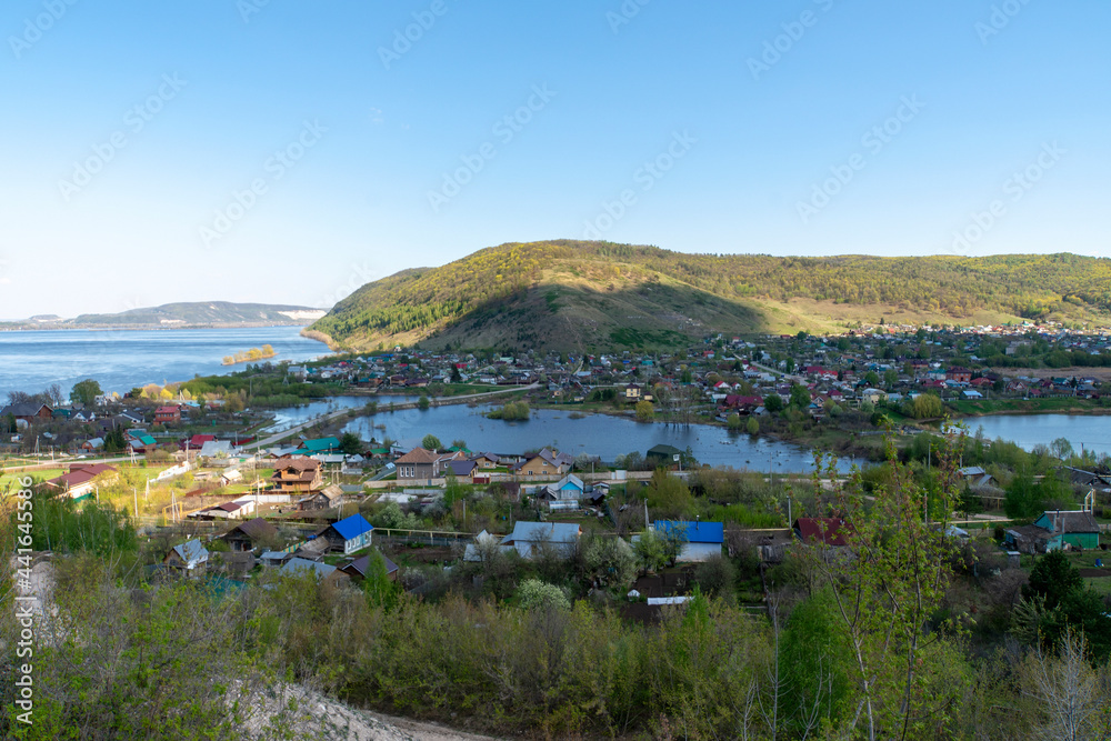 Small town on the background of the river and mountains.