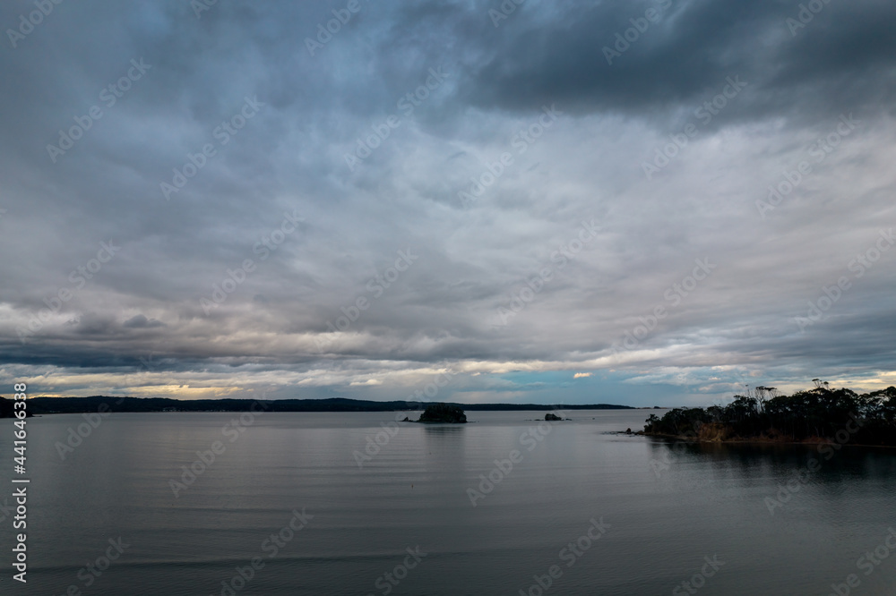 Rain clouds and aerial reverse sunset seascape at Corrigans Beach
