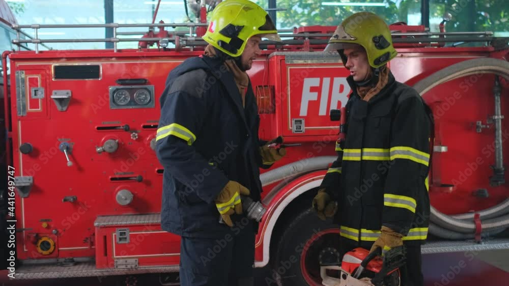 Two fireman hold tools and discuss together for preparation of firefighting. Two fireman hold tools and discuss together for preparation of firefighting.