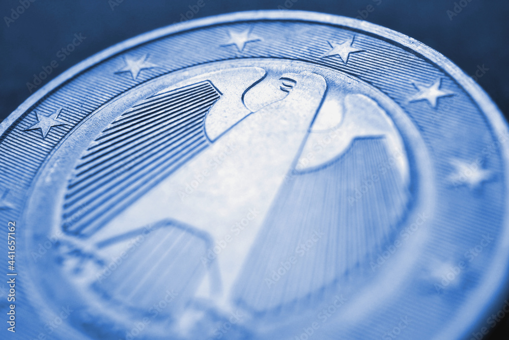 1 euro coin issued in Germany close-up. Obverse with the Federal Eagle. Blue tinted economic background or backdrop. European Union currency and economy news. Macro