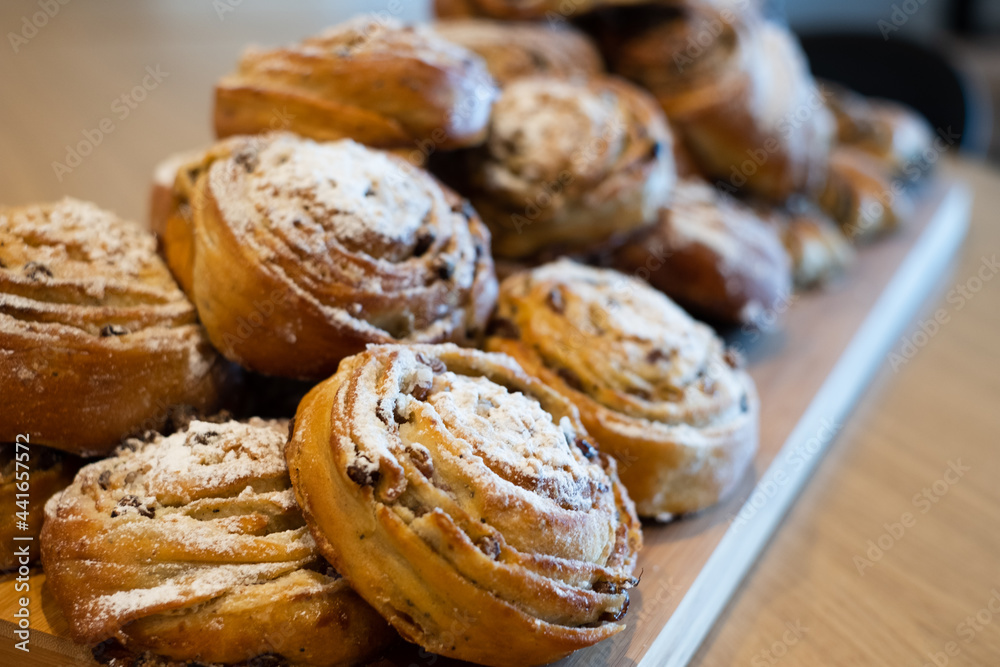 Cardamom buns. Traditional Nordic baked sweet breads on a wooden board. Breakfast food. Cardamom buns. Traditional Nordic baked sweet breads on a wooden board. Breakfast food.