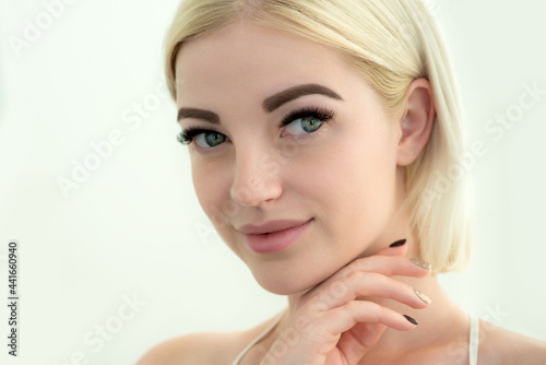 Beauty smiling blonde model with natural nude make up and long eyelashes. Skin care, Spa and wellness concept. Make up, long hair and lashes. Close up, selective focus