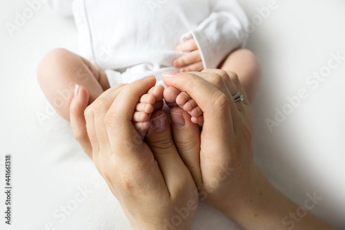 hands of parents. the legs of the newborn in the hands of mom and dad. baby s legs in his hands. 