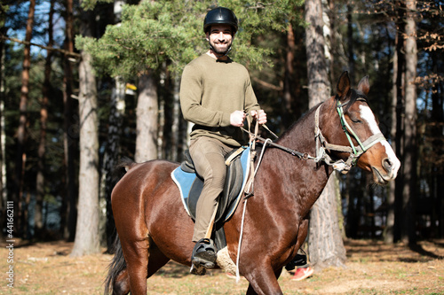 Young Man Wearing Helmet and Riding Horse