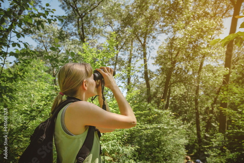 Young woman bird watching with binoculars at Indiana Dunes State Park photo