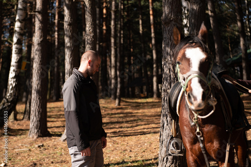 Young Man Standing Near Horse Preparing to Ride