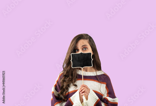 Beautiful woman, young lady, girl is showing a small board, tablet, iPad, covering face, mute