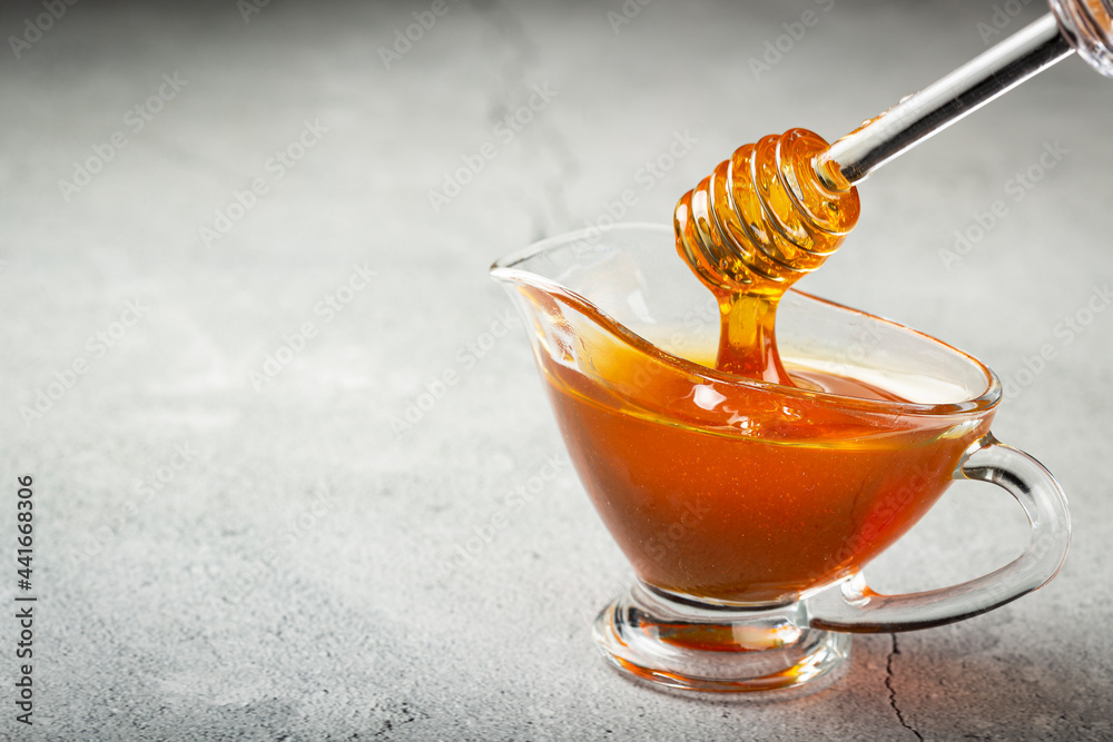 Honey in glass bowl on the table.