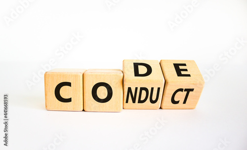 Code of conduct symbol. Turned the wooden cube and changed the word code to conduct. Beautiful white background. Business and code of conduct concept. Copy space.