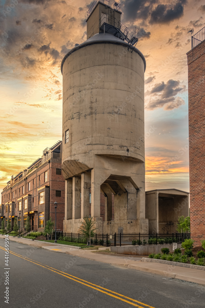 Restored concrete coal tower in Charlottesville Virginia used for supplying steam locomotives at the railway station, now integrated into a luxury house complex with dramatic sunset sky