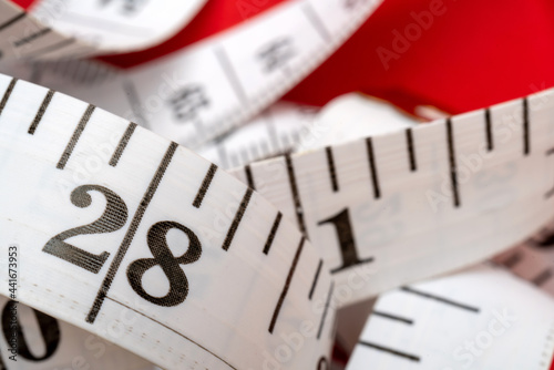 Measuring tape on a red background photo