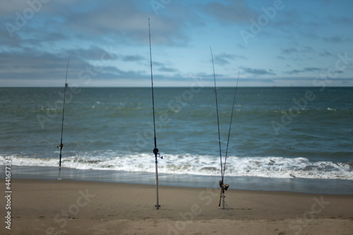 fishing poles, rods on the beach seashores with sand and blue sky © PIERRE JEAN C