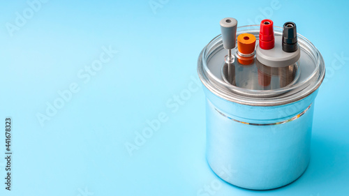 Thermodynamics, calorimetry test and scientific measuring of heat capacity concept with metal calorimeter isolated on blue background with copy space photo