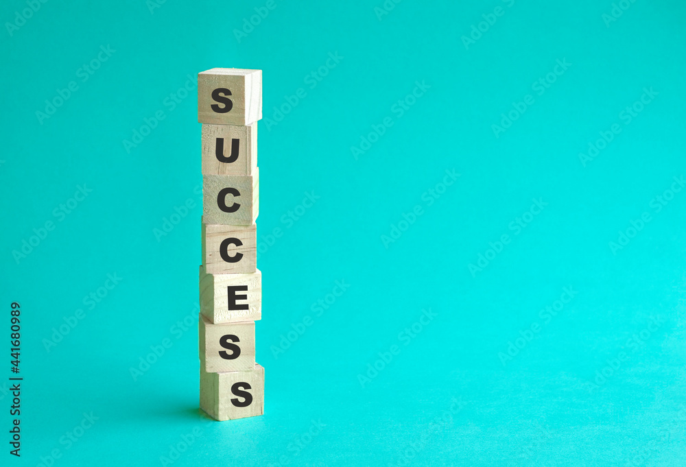 Word Success on wooden cubes stacked in pillar form. Blue background, copy space. Word Success on wooden cubes stacked in pillar form. Blue background, copy space.