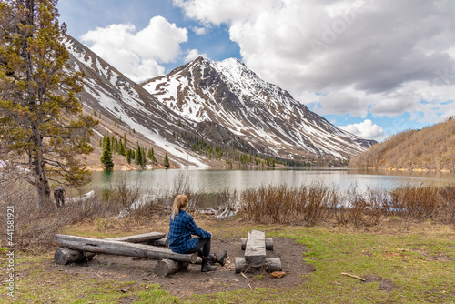 Hiker enjoying the scenic view of St Elias Lake in Kluane National Park during spring time after day hike through the wilderness of Yukon Territory. 