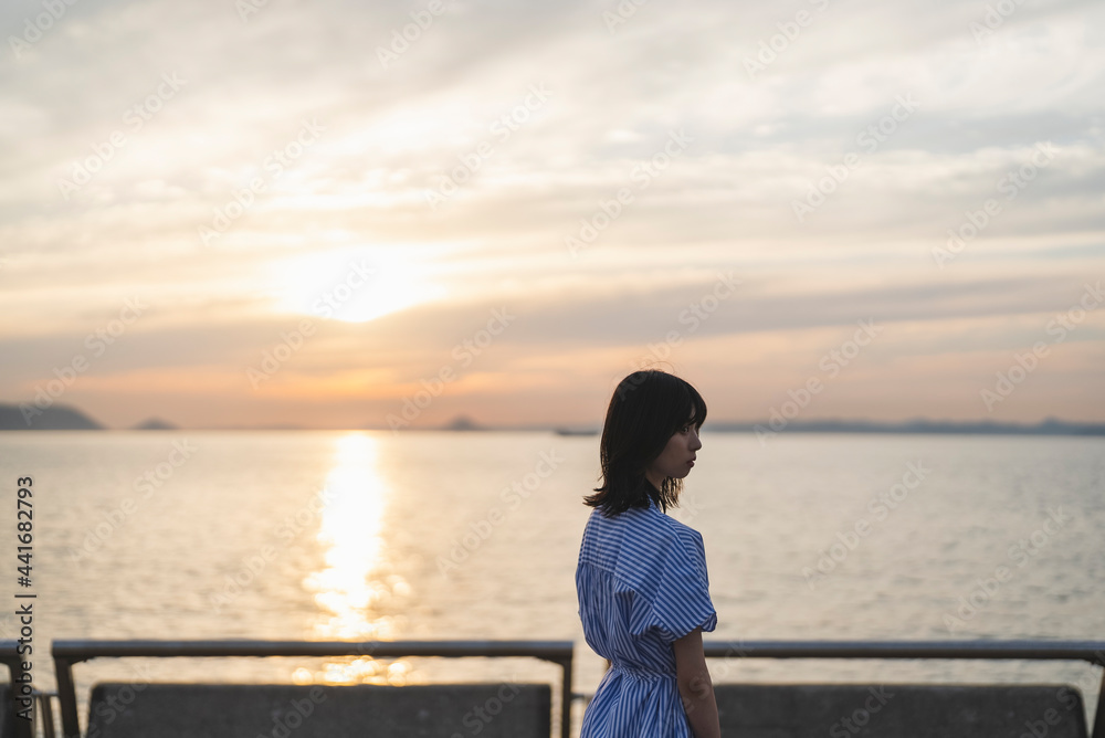 夕暮れの海にいる女性