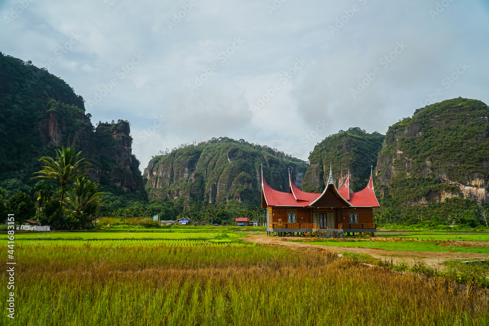 Fototapeta premium Minangkabau house/Rumah Gadang in a beautiful landscape view of Harau Valley with mountains valley and grass view, West Sumatra, Indonesia. Beautiful Minangkabau, Indonesia Landscape.