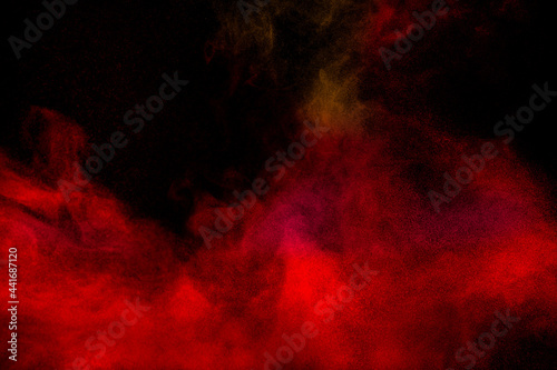 Red particles explosion on black background.Freeze motion of red dust splash. © Pattadis