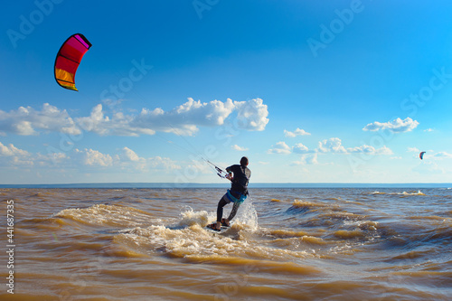 Photography Kiteboarder surfing waves with kiteboard on a sunny summer day.