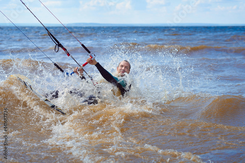 Canvas Print Kiteboarder surfing waves with kiteboard on a sunny summer day.