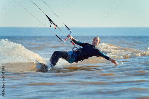 Photography Kiteboarder surfing waves with kiteboard on a sunny summer day.