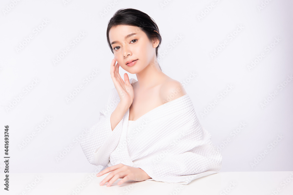 Beautiful young Asian woman wearing bathrobe on white background, Face care, Facial treatment, Cosmetology, beauty and spa Concept. Beautiful young Asian woman wearing bathrobe on white background, Face care, Facial treatment, Cosmetology, beauty and spa Concept.