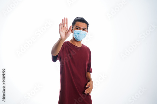 Covid19, the concept of health care and medicine. A young man standing in a face mask with hand gesture 