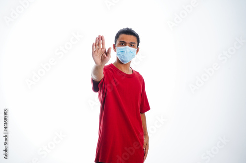 Covid19, the concept of health care and medicine. A young man standing in a face mask with hand gesture 