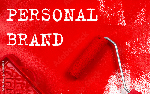 Roller brush with red paint with text PERSONAL BRAND , business concept, photo