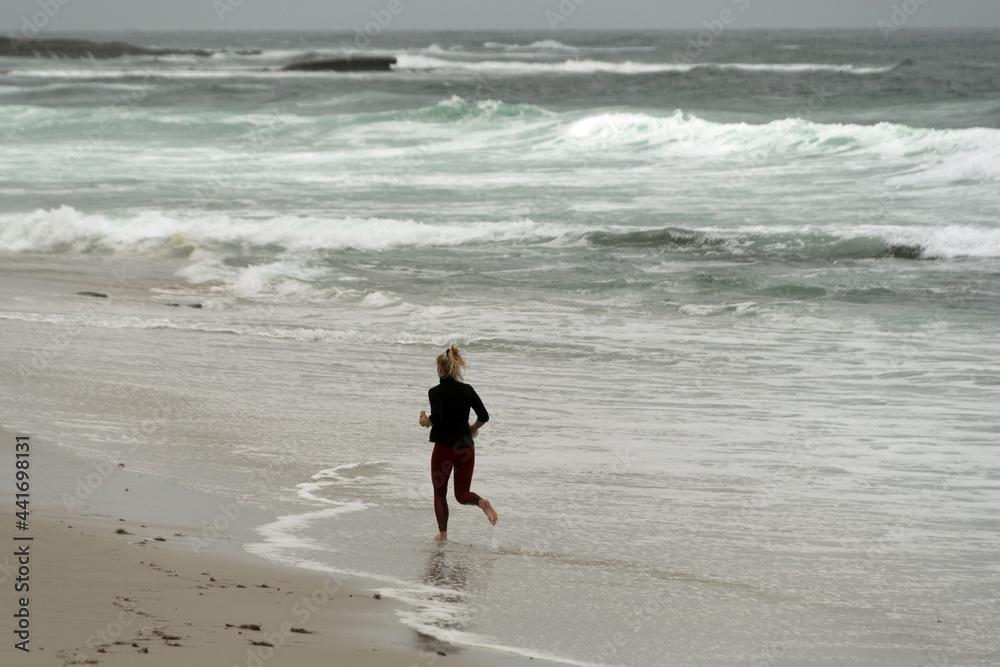 Female runner in shallow water near Big ROck Reef, La jolla Female runner in shallow water near Big ROck Reef, La jolla