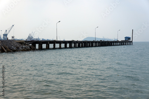 The jetty for loading in the sea on blue sky background with copy space.       © Shinpanu