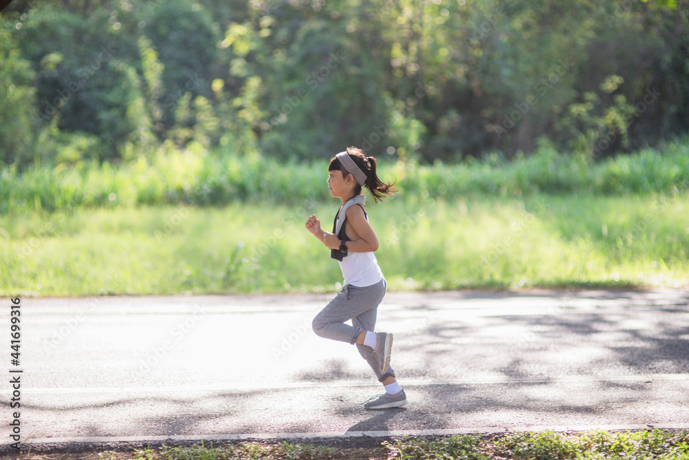 happy child girl running in the park in summer in nature. warm sunlight flare. asian little is running in a park. outdoor sports and fitness, exercise and competition learning for kid development. happy child girl running in the park in summer in nature. warm sunlight flare. asian little is running in a park. outdoor sports and fitness, exercise and competition learning for kid development.