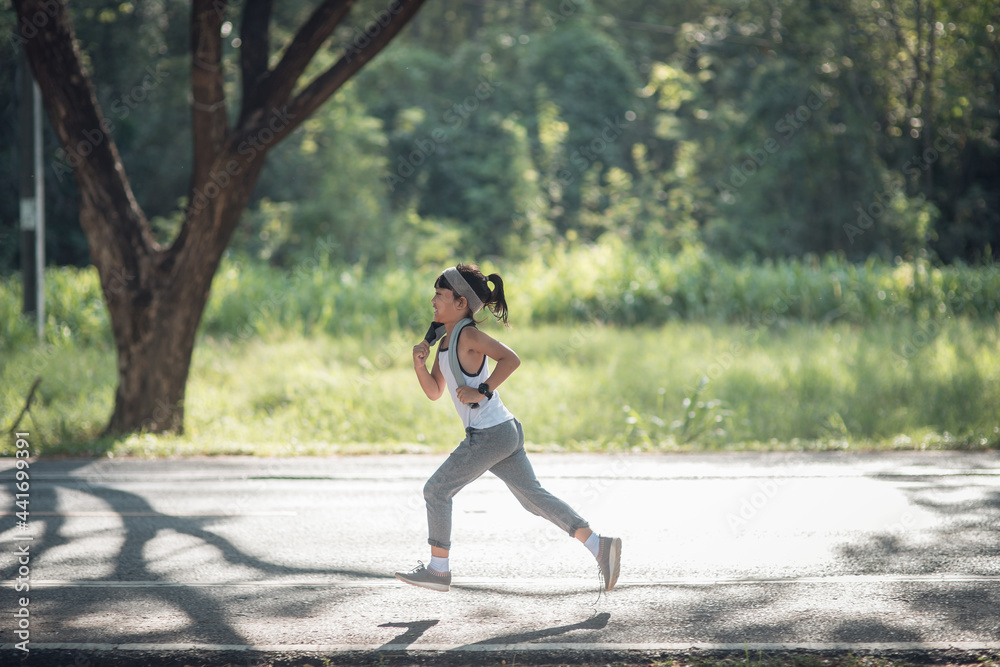 happy child girl running in the park in summer in nature. warm sunlight flare. asian little is running in a park. outdoor sports and fitness, exercise and competition learning for kid development. happy child girl running in the park in summer in nature. warm sunlight flare. asian little is running in a park. outdoor sports and fitness, exercise and competition learning for kid development.