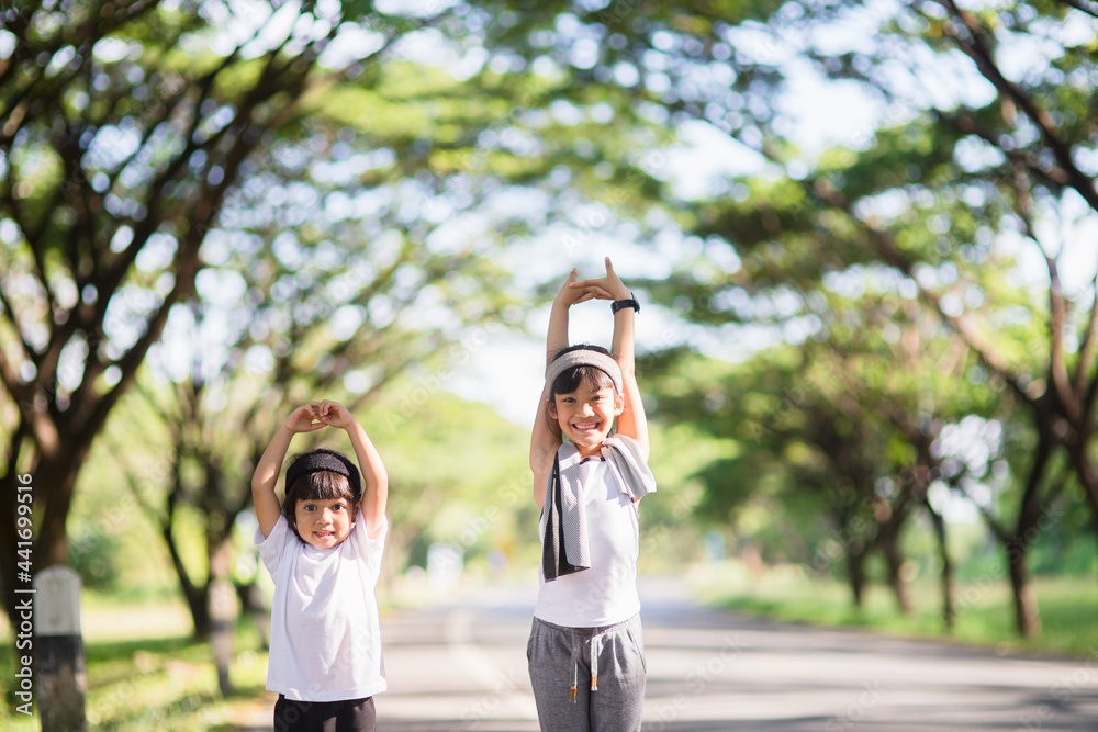 Two asian little girls having fun and running together in the park in vintage color tone Two asian little girls having fun and running together in the park in vintage color tone