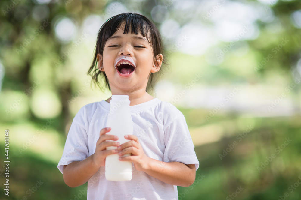 Cute asian little child girl is drinking a milk, soft focus Cute asian little child girl is drinking a milk, soft focus