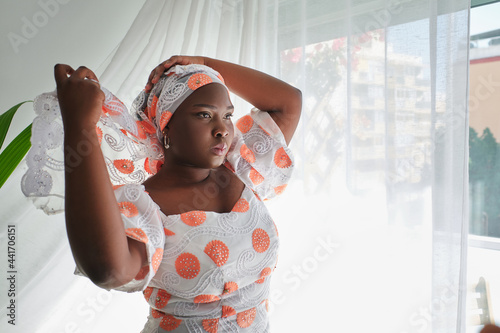 Gorgeous young black female covering head with traditional turban