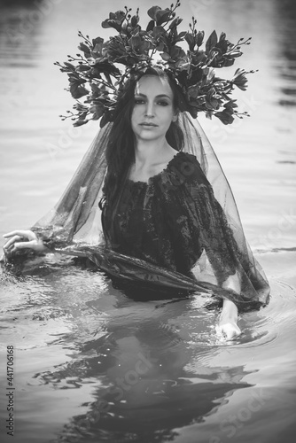 Black bride at water, Slavic rituals, pagan magic scene, old magic power concept photo