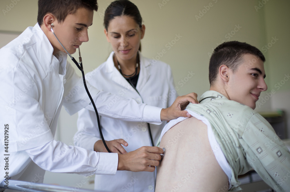 © liderina - Young student checks a patient's lungs in a hospital room.