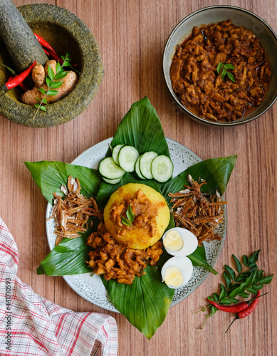 Traditional Malaysian Peranakan cuisine / Nasi Kunyit aka Turmeric Glutinous Rice / Delicious dish eaten with dry curry chicken with glutinous rice cooked in coconut milk and turmeric photo