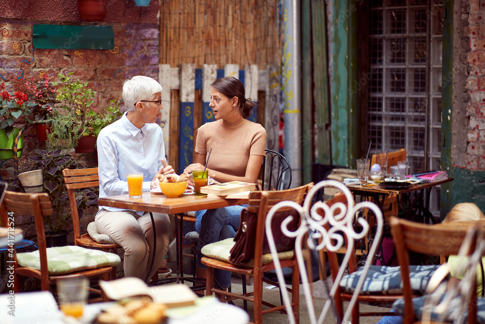 serious talk between two caucasian women, elderly and young, looking each other. serious talk between two caucasian women, elderly and young, looking each other.