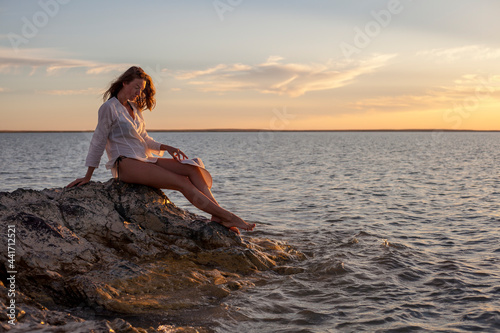 Beautiful woman enjoying sunset on the beach.