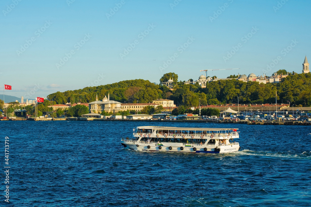 Boats ferry commuters and tourists to and from the busy Sultanahmet and Eminonu waterfront. The Green Crescent building and Topkapi Palace can be seen in the background
