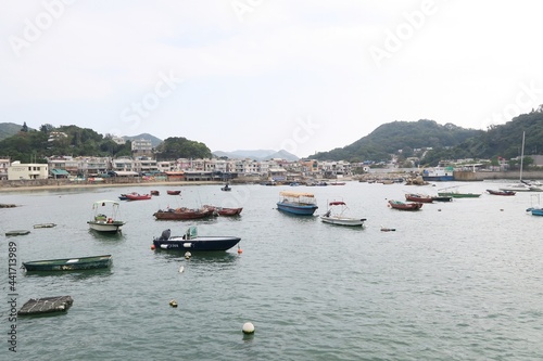 The view of the houses along the shore of Lamma Island. There are lots of fishing boats in the sea also