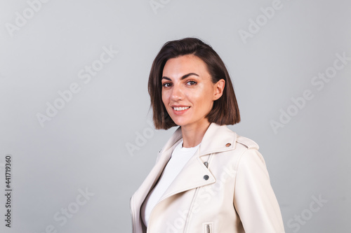 Woman in leather jacket on gray background