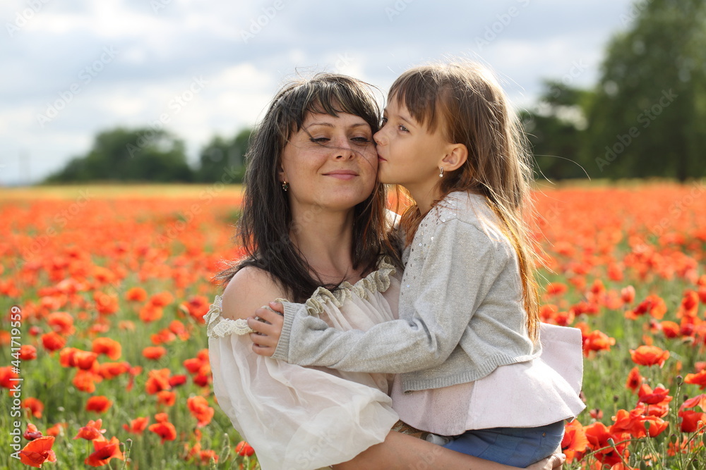 Mother and daughter are walking in a beautiful field of poppies Mother and daughter are walking in a beautiful field of poppies