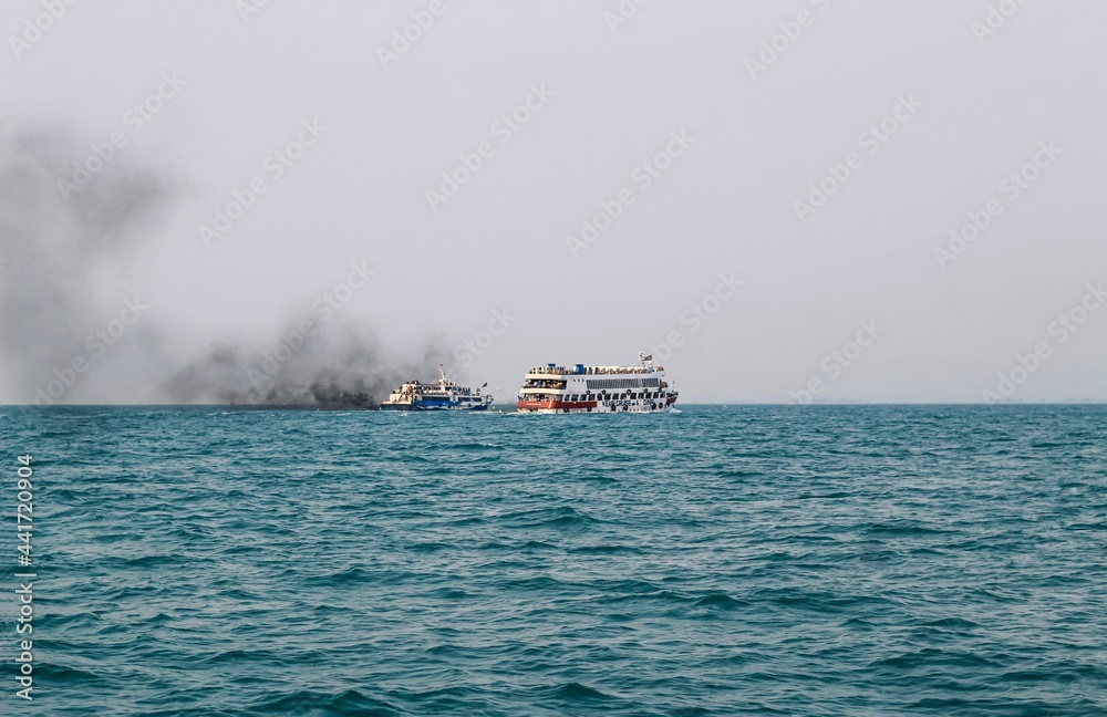 Ferry boat of Bay of Bengal smoke coming from its chimney. Black exhaust fumes coming from the chimney of a moored tanker after main engine ignition. Black Smoke from Ship Sailing on the High Sea.