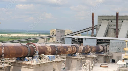 An industrial cement processing facility. Rotating furnace equipment at the factory, working in an electric furnace. Rotary kiln (RKF). Roasting rotary kiln at a cement plant.