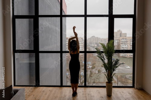 Female silhouette on the background of the city in a panoramic window